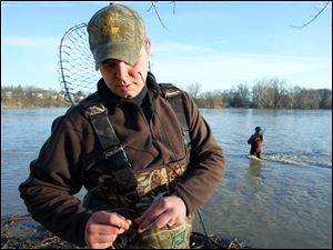 Mike Johnson ties on a new lure while fishing for walleye at Orleans Park in Perrysburg. The Albert Lea, Minn., man and his father, Jerry, are spending four days fishing for walleye in the area, he said. Conditions for outdoor activities are expected to be ideal today and tomorrow with highs of about 70 under mostly sunny skies, but Saturday will bring a chance of showers. Temperatures will drop considerably to start next week, with rain likely Sunday and a high only in the 40s. 