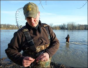 Mike Johnson ties on a new lure while fishing for walleye at Orleans Park in Perrysburg. The Albert Lea, Minn., man and his father, Jerry, are spending four days fishing for walleye in the area, he said. Conditions for outdoor activities are expected to be ideal today and tomorrow with highs of about 70 under mostly sunny skies, but Saturday will bring a chance of showers. Temperatures will drop considerably to start next week, with rain likely Sunday and a high only in the 40s. 