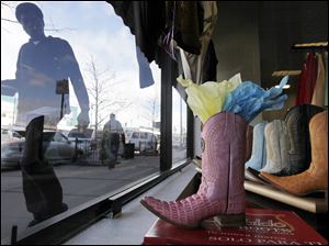 Merchandise displayed in the window of a Chicago store tempts consumers, who are struggling during a moderate economic recovery. Consumer prices were flat in February. Prices rose for food but were offset by lower costs for energy, cooling inflation fears.
