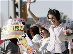 the blade/amy e. voigt Amanda Metcalf, right, and Mary Mangold of Toledo protest at the corner of Cherry and Summit streets. The Children of Liberty, a conservative-libertarian group, organized the demonstration.