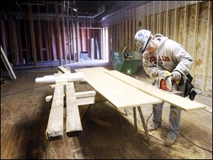 Slug: BIZ BUILD21p  Date:  03162010     Andy Morrison       Location: Toledo Caption: Matt Reynolds, a carpenter with The Spieker Company, Perrysburg, cuts wood to repair damaged floor of the new home of Thomas Porter Architect at 8 North St. Clair Street, Tuesday, 03162010. This actual part of the building is being renovated to be leased out. Summary.