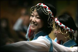 Aige Guo joins in a Tibetan dance during the Toledo Sister Cities International Festival at the Erie Street Market. She was one of many performers to display dances from various cultures.