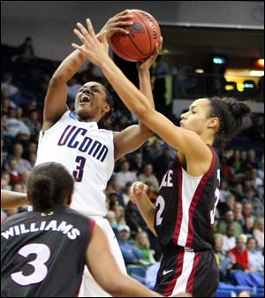 Connecticut's Tiffany Hayes shoots over Temple's Natasha Thames, right, and B.J. Williams.