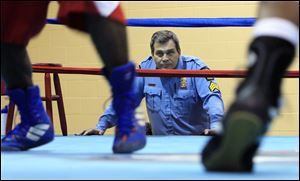 Sergeant Youngs watches Alex Alexander and DeAndre Ware, Jr., in the boxing ring.


