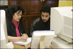 Susan Milliron helps Adrian Williams, 17, with work in a Polar Academy late-afternoon session at Woodward High School.