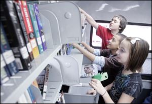 Looking for books and movies inside the new bookmobile in Northwood are, from front to back, Kaleigh Schroeder, K.J. Hardeman, and Prometheus Wright, all 11.
