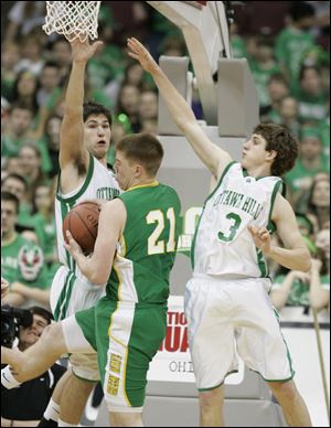 Jon Shollenberger, left, and Andrew Jamieson of Ottawa Hills try to stop Newark Catholic's Nate Adams in theDivision IV state semifinals in Columbus.