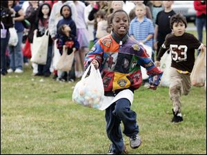 A rush for eggs — thousands of the colored plastic kind filled with candy, money, or trinkets  — results in full bags for children at the Church on Strayer in Monclova Township.