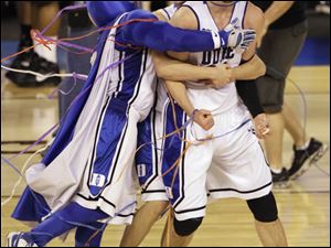 Duke players Brian Zoubek, right, Jon Scheyer, center, and the team mascot celebrate after Duke's 61-59 win over Butler in the men's NCAA Final Four college basketball championship game Monday in Indianapolis. 
