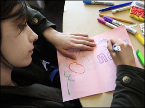 Owens student Lydia Kwapich of Waterville colors a card designed to uplift a cancer patient.