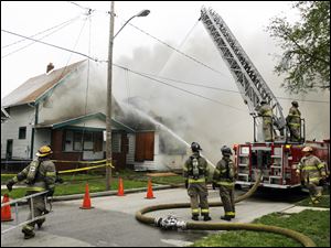 Toledo firefighters battle a blaze described as suspicious at two vacant South Toledo structures. Both houses were unoccupied, assistant Toledo Fire Chief Luis Santiago said. The fire began at 355 Havre St. near Western Avenue shortly before 4 p.m. yesterday and quickly spread to the upper floor of 353 Havre.