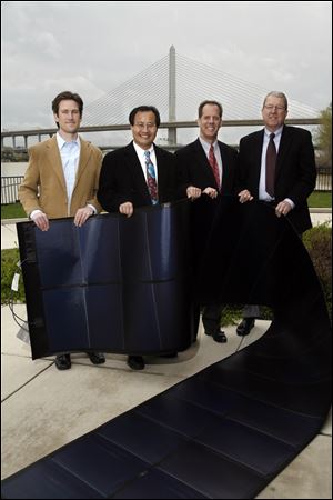 Officials of Xunlight Corp. of Toledo display one of the firm's solar panels at the announcement that Xunlight and First Solar Inc. will supply panels for the project, expected to be operating by late autumn. From left are Todd Armstrong, CEO and President Xunming Deng, David Swank, and John Buckey.