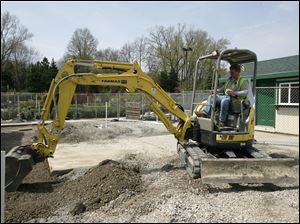 BIZ build18p  Bill Dittman, of Toledo, smoothes the ground adjacent to the new building. This area will be the new gardening area. Rudloph/Libbe workers are building an addition to The Anderson's store at Talmadge and Monroe in Toledo, Ohio on April 14, 2010. Jetta Fraser/Toledo Blade
