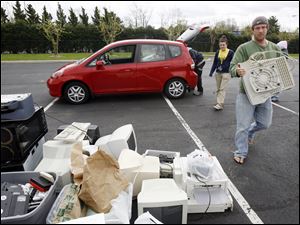 Slug: CTY earthday17p B The Blade/Jeremy Wadsworth    Date: 04/17/10  Caption: Joe Neeb of Toledo, Ohio, drops of an old computer to be recycled Saturday, 04/17/10, at the Toledo Zoo during Earth Day festivities.