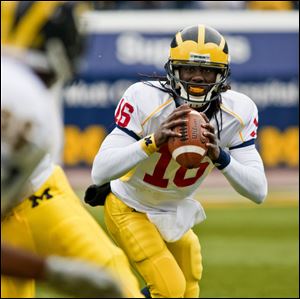 Michigan quarterback Denard Robinson threw and ran for touchdowns yesterday before 35,000 fans at the annual spring game.