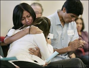 Samantha, facing the camera, hugs her sister, Jenny, 17, who cries after speaking about her mother's deportation. The women, who didn't want their last names given, attended the FLOC event.