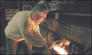 Chris Werkman takes his turn cooking the traditional steak dinner in the fireplace at the club.