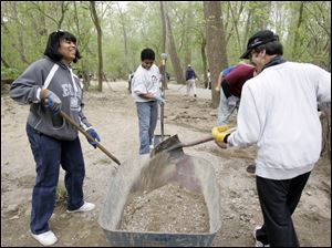 Slug: CTY cleanup19p                         Date 4/18/2010 Toledo Blade/Amy E. Voigt                     Location: Toledo, Ohio  CAPTION:  Montina Gordon, left, AJ, center, CANNOT USE LAST NAME) and Mike Zerner, right,  from Toledo and the Big Brothers and Big Sisters of Northwest Ohio, work on building a trail at Swan Creek Metropark as part of a Community Service Earth Day Project.