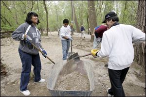 Slug: CTY cleanup19p                         Date 4/18/2010 Toledo Blade/Amy E. Voigt                     Location: Toledo, Ohio  CAPTION:  Montina Gordon, left, AJ, center, CANNOT USE LAST NAME) and Mike Zerner, right,  from Toledo and the Big Brothers and Big Sisters of Northwest Ohio, work on building a trail at Swan Creek Metropark as part of a Community Service Earth Day Project.