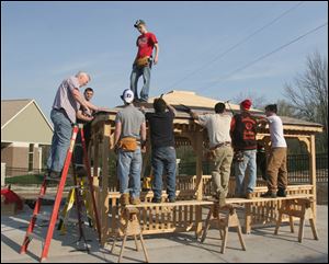 Bob Johnson, left, leads a group of construction-technology students from  Northview and Southview high schools in roofing a gazebo behind the Goerlich Center at Flower Hospital.
