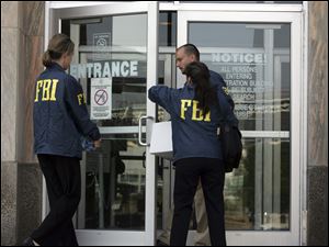On July 28, 2008 , FBI agents enter a city-county building in downtown Cleveland during an investigation of public corruption. The same day, agents raided the homes of Cuyahoga County Commissioner
Jimmy Dimora, at far left, and county Auditor Frank Russo, near left. Neither has been charged and both deny wrongdoing, but voters nevertheless opted to change their government.