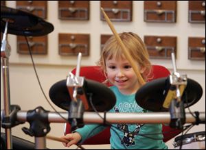 The ‘Bang a Drum' event is a hit with Sabina Bielski, 3, of
Waterville. Saturday's celebration of Jazz Appreciation Month at the Main Library included 13 local jazz acts.
<br>
<img src=http://www.toledoblade.com/graphics/icons/photo.gif> <font color=red><b>PHOTO GALLERY</b></font>: <a href=
