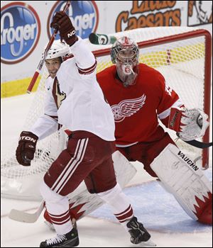 Taylor Pyatt of Phoenix celebrates a goal by Mathieu Schneider against Detroit goaltender Jimmy Howard in yesterday's playoff game. It ended an 0-for-19 power-play drought for the Coyotes.