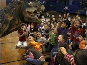 NBRS dino05p   Holland Elementary School first and second Grade students with a baby tyrannosaurus rex at the Holland, Ohio school on April 26, 2010. Holland Elementary School First and Second Grade students and staff were selected to receive a visit from a baby T-Rex from the Walking With Dinosaurs show. Jetta Fraser/Toledo Blade