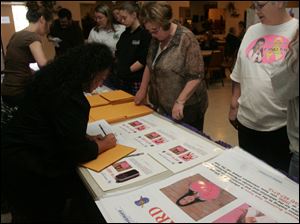 CTY nevaeh 26p   04/026/2010       The Blade/Lori King  Risa Thompson, left, signs out posters during the Nevaeh Buchanan Reward Poster Campaign at the Moose Lodge in Monroe, Mich. Watching at right is Nevaeh's great aunt, Diana Lawson.