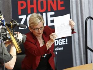 Michigan Gov. Jennifer Granholm holds up the state's texting-while-driving ban law after signing it Friday, April 30, 2010 in Detroit, during a broadcast of 