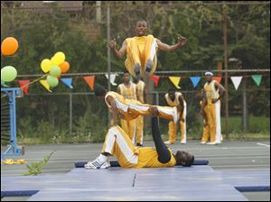 Slug: CTY acrobats03p                               Date 5/02/2010 Toledo Blade/Amy E. Voigt                Location: Toledo, Ohio  CAPTION:  Deshawn McClinton, with The Chicago Boyz Acrobatic Team, flips over his teammates in an acrobatic feat in honor of the holiday Lag B'Omer at the Jewish Community Center on Sunday on May 2, 2010. The event was sponsored by the Chabad House of Toledo and The Friendship Circle.