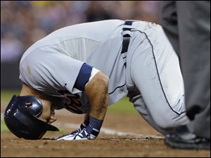 Detroit's Gerald Laird collapses in pain after fouling a ball off his left shin in the fifth inning.