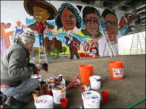Visiting artist Mario Torero of San Diego, California, mixes paint while working on the Old South End Mural Project.