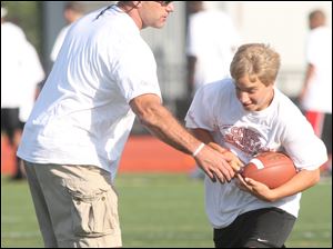 Chris Spielman is very hands-on with the football camp he runs in suburban Columbus. While teaching kids the proper techniques of football, he mixes in life lessons.