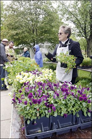 Phyllis Hyder, a volunteer with the Maumee Valley Herb Society discusses some of the group's offerings at the sale.