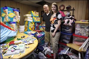 Nick Lake and Lauren Hablitzel-Lake are surrounded by towers of formula, boxes of diapers, and other supplies in the pasement of Lauren's parents' Perrysburg Township home, where the super-size family is staying.