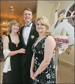 Julie and Brad Rubini and Christina Dunn, right, enter the Toledo Rotary Foundation gala.
