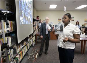 Monique Rodgers, a sixth-grade student at Stewart Academy for Girls, shows a photo of the Toledo area to a class in South Africa via a computer hookup.