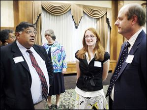 Bob Vasquez, president of the Toledo school board, left, and Start High School salutatorian Laura Zielinski, center, and her father, Paul Zielinski, discuss Miss Zielinski's plans for college.