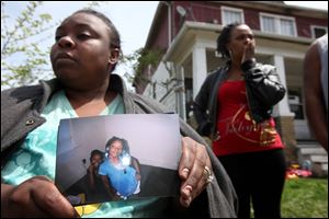 Charles Jones talks about the loss of his daughter, Aiyana. He said the slaying suspect whom police arrested had been in the duplex's upstairs apartment that officers raided at the same time as his. Krystal Sanders shows a photo of her niece, Aiyana Jones, shot when a police officer's gun discharged during a search of the duplex where the child lived.