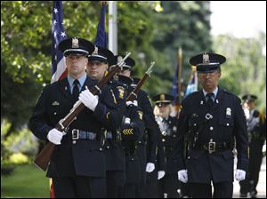 Toledo Police Department honor guard members Mike Talton, left, and Al Cavanaugh present the colors at the ceremony.