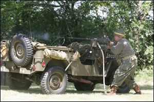 Frank Domalski of Sylvania fires an M1919A4 from behind a World War II-era Jeep during a re-enactment sponsored by the village of Whitehouse. Hundreds of people turned out for the event. 