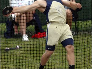 St. John's Cody Riffle has both feet of the ground as he sends discus flying in winning effort.