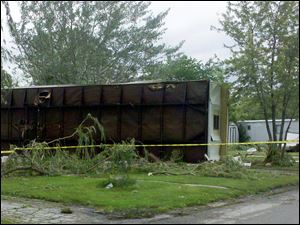 A residence at Friendly Village Mobile Home Park in Lake Township rests on its side Sunday morning after being blown over in the storm.
