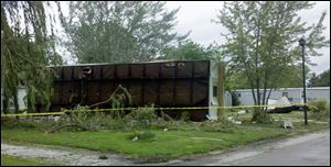 A residence at Friendly Village Mobile Home Park in Lake Township rests on its side Sunday morning after being blown over in the storm.