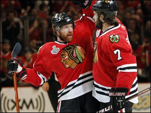 The Blackhawks' Brian Campbell, left, congratulates Brent Seabrook after Seabrook scored a goal in the first period, helping Chicago build a 3-0 lead by the first intermission.