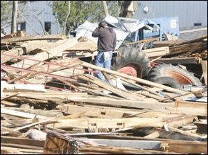 A man surveys the damage to a structure off 795 near Cummings Road in Lake Township, Wood County, Sunday.