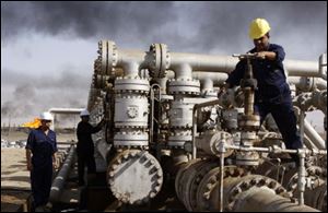 Iraqi workers are seen at the Rumaila oil refinery, near the city of Basra, Iraq, in this Dec. 13, 2009 file photo.