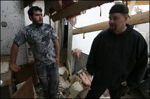 David Northam, left, and his friend Robert J. Rudat assess the damage to Mr. Northam's future father-in-law's apartment on Dennison Road, site of some of the worst devastation in Dundee.