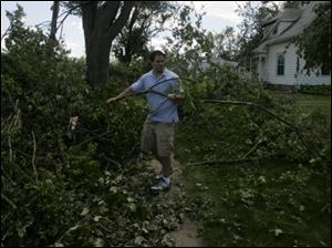 Don Merkle clears a fallen tree in front of his home. The ex-Army medic said the storm was one of the most frightening experiences of his life. 'I was more scared … than I was out in Iraq.'